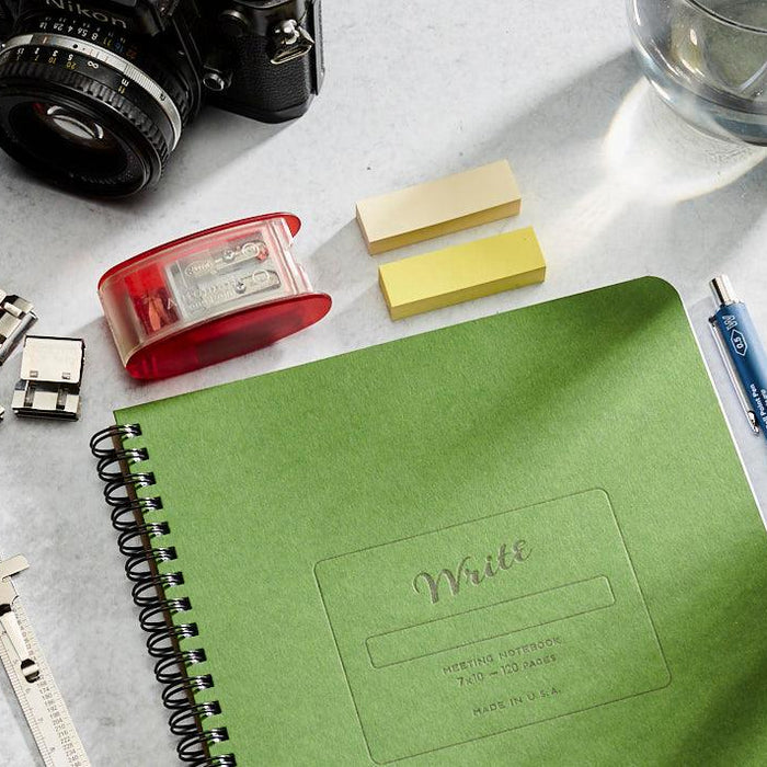 Notebook on a desk with pens and pencils